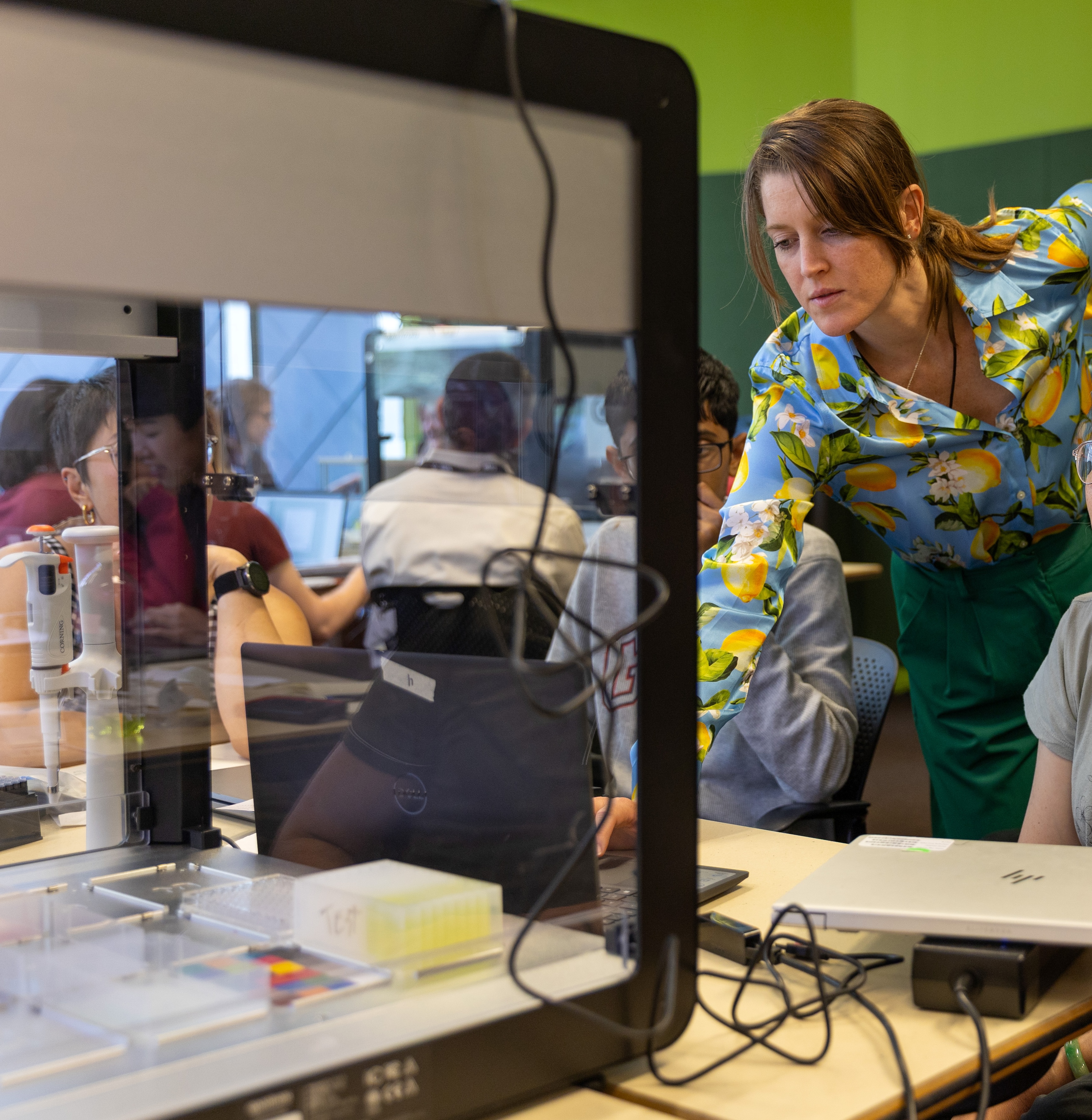 Kennedy McDaniel Bae working with students on lab automation equipment